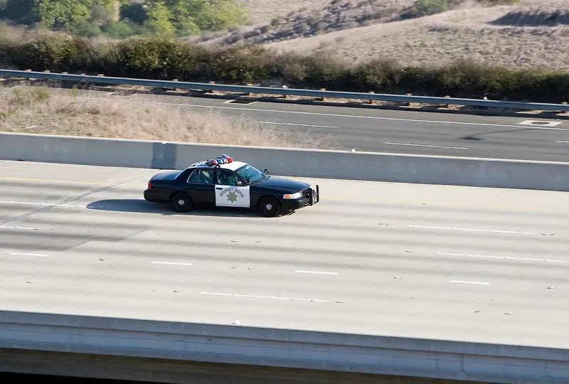 GettyImages-172217544 Police car driving on empty highway.